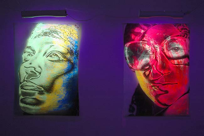 black light art gallery showing two portrait pictures